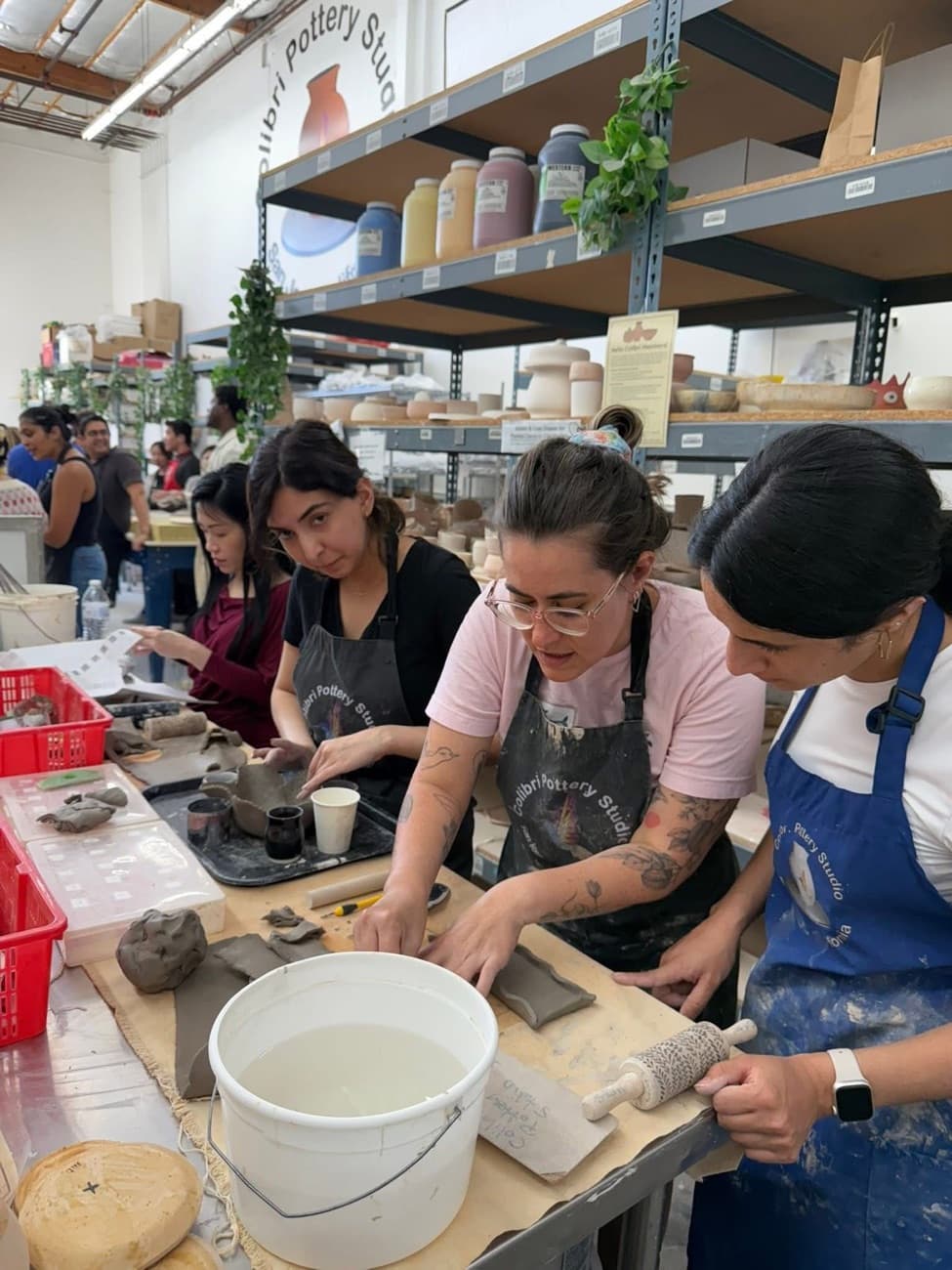 A Colibri instructor guiding students through a hand-building project